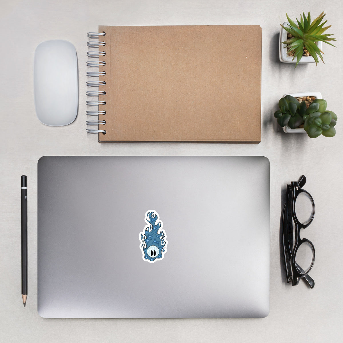 Sticker feu follet bleu 7,6 x 7,6 cm Inari and the Wisps collé sur un ordinateur portable, posé sur un bureau.